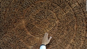 A religious teacher shows a carving of Koran at the Islamic Boarding School of Ashriyyah Nurul Iman in Parung, West Java, Indonesia, July 16, 2013. Students read the Koran during the holy month of ramadan. (Photo by Veri Sanovri/Xinhua/Sipa USA)